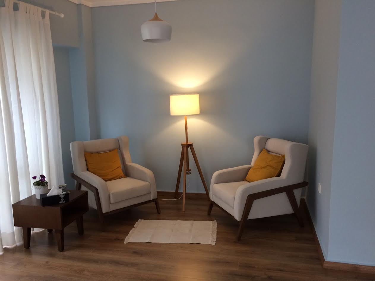 two chairs facing each other on a wooden floor and a yellow light lump between them